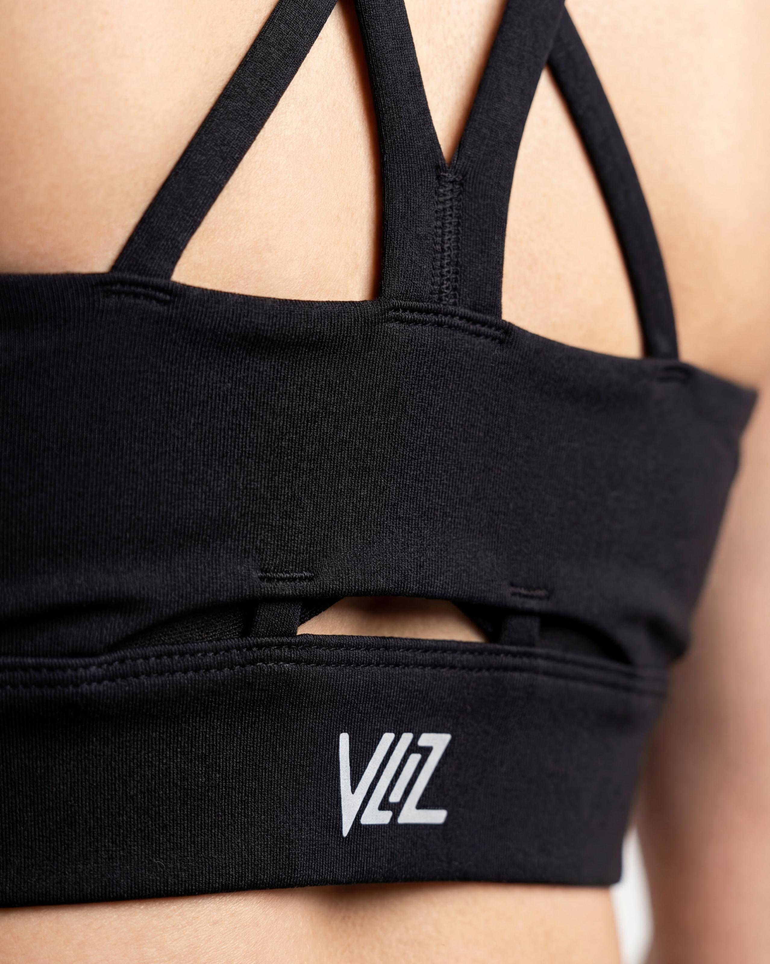 VLIZ AuraFlow Cross-Back Sports Bra, black, with smooth fabric and a supportive fit. The design features elegant double cross-back straps and a discreet keyhole detail below the straps. Ideal for gym workouts, yoga, Pilates, and everyday training.