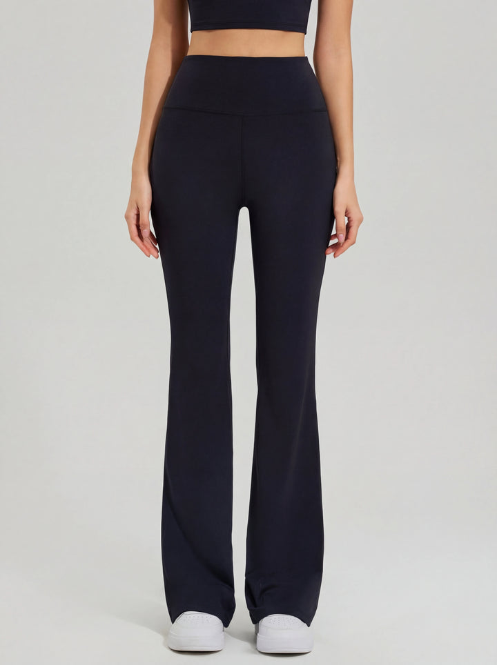 Person wearing black high-waisted leggings on a light gray background