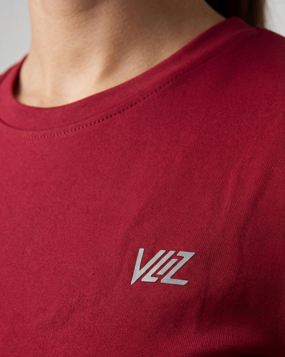 A model wears a form-fitting, short-sleeved deep red crew neck t-shirt. The smooth fabric highlights a comfortable, athletic fit suitable for workouts or casual wear.