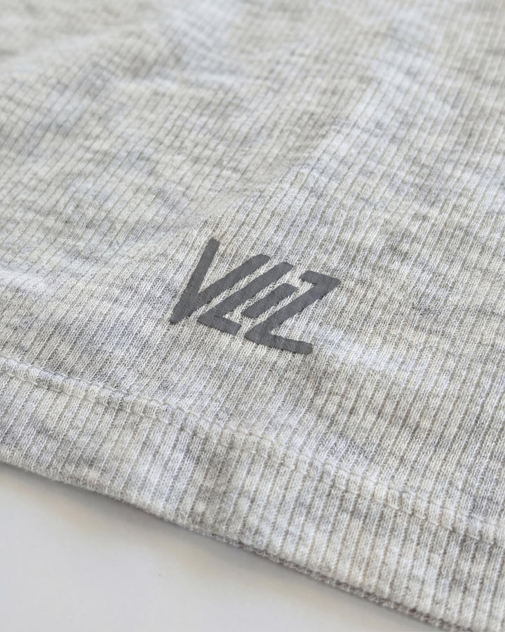 VLIZ Soft-Ribbed Padded Tank Top; a blonde woman models a light grey ribbed tank top with built-in pads and a supportive racerback design, paired with black leggings against a white background. Ideal for gym workouts, yoga, Pilates, and everyday training, highlighting its comfortable, flattering fit.