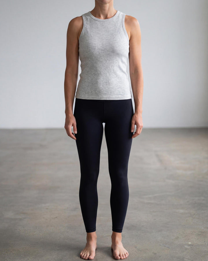 VLIZ Soft-Ribbed Padded Tank Top; a blonde woman models a light grey ribbed tank top with built-in pads and a supportive racerback design, paired with black leggings against a white background. Ideal for gym workouts, yoga, Pilates, and everyday training, highlighting its comfortable, flattering fit.