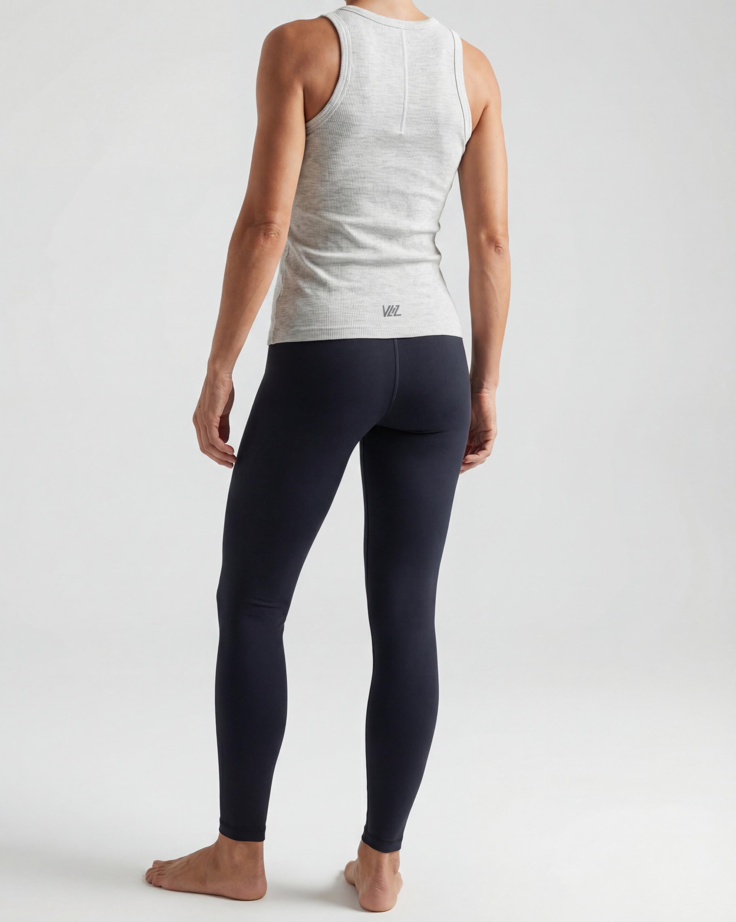 VLIZ Soft-Ribbed Padded Tank Top; a blonde woman models a light grey ribbed tank top with built-in pads and a supportive racerback design, paired with black leggings against a white background. Ideal for gym workouts, yoga, Pilates, and everyday training, highlighting its comfortable, flattering fit.
