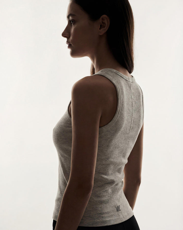 VLIZ Soft-Ribbed Padded Tank Top; a blonde woman models a light grey ribbed tank top with built-in pads and a supportive racerback design, paired with black leggings against a white background. Ideal for gym workouts, yoga, Pilates, and everyday training, highlighting its comfortable, flattering fit.