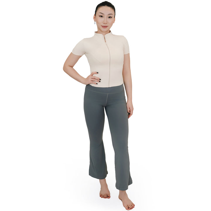 Full-body view of VLIZ Full-Zip SculptFit Short Sleeve Top in White, styled with flare leggings for a balanced and sleek athletic silhouette.