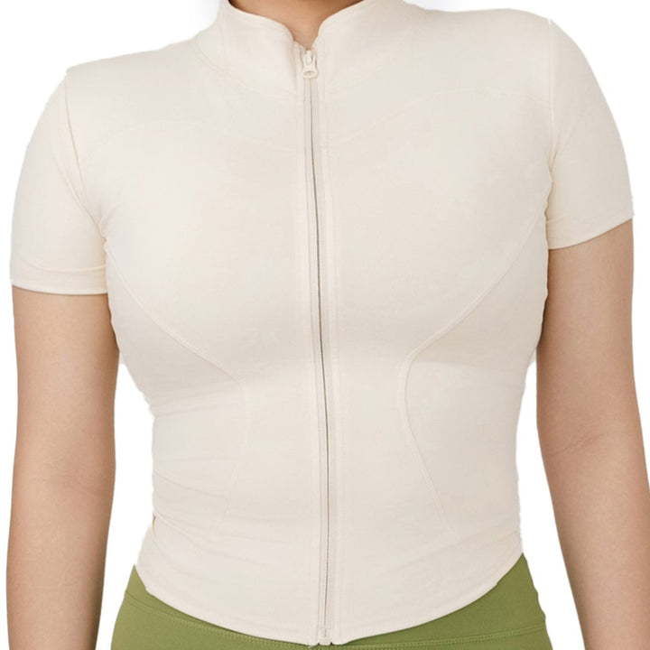 Close-up of VLIZ Full-Zip SculptFit Short Sleeve Top in White, highlighting curved seamlines and mock neckline with front zipper detail.