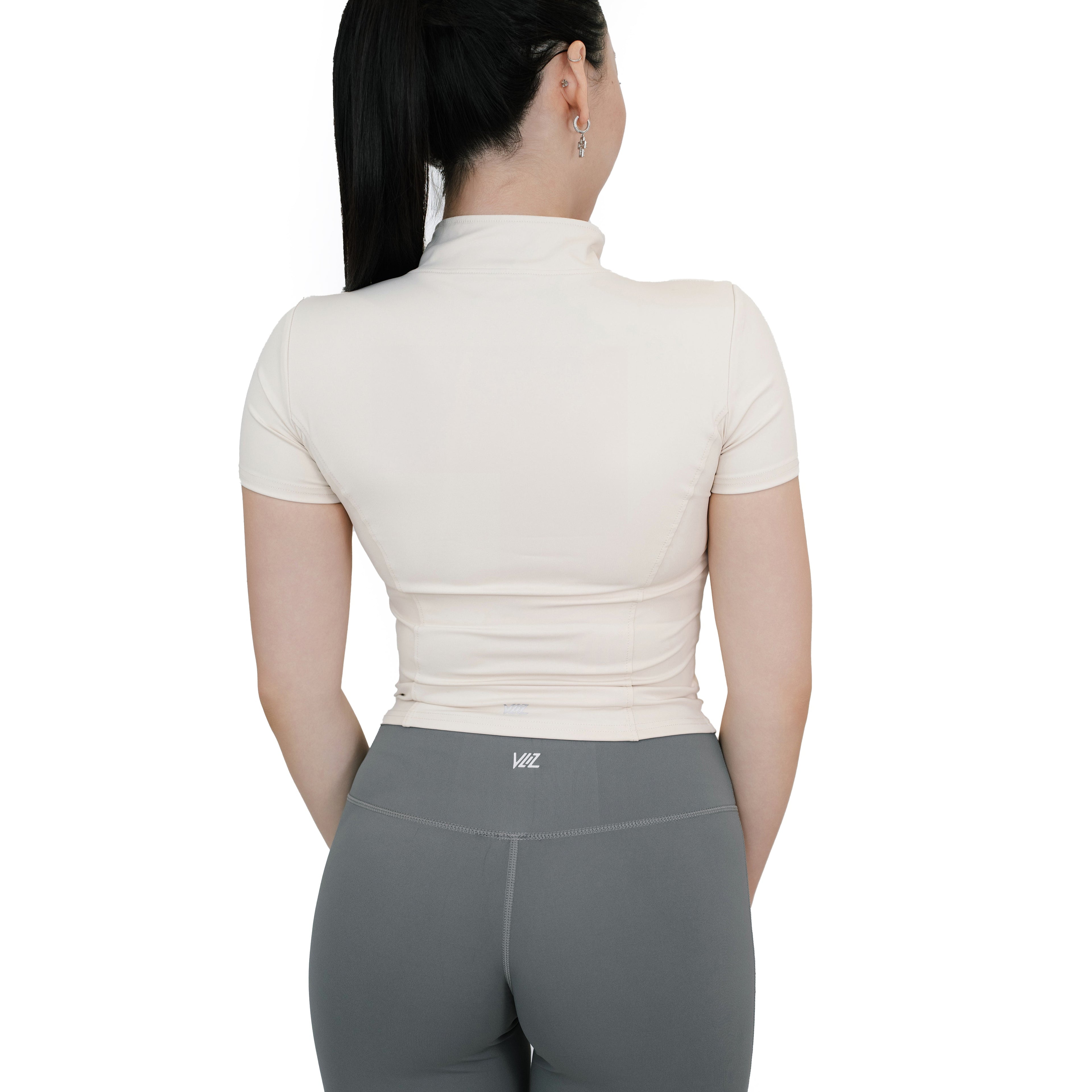 Back view of VLIZ Full-Zip SculptFit Short Sleeve Top in White, featuring mock neck collar and contour-enhancing seam details.