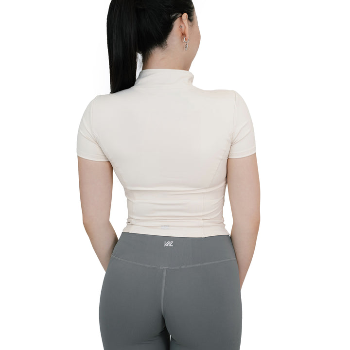 Back view of VLIZ Full-Zip SculptFit Short Sleeve Top in White, featuring mock neck collar and contour-enhancing seam details.