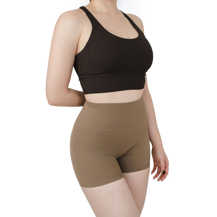 Model wearing the VLIZ ContourFlex Cross-Back Sports Bra in dark brown, angled front view highlighting the scoop neckline, ribbed sculpting fabric, and secure wide underband for medium-impact support.