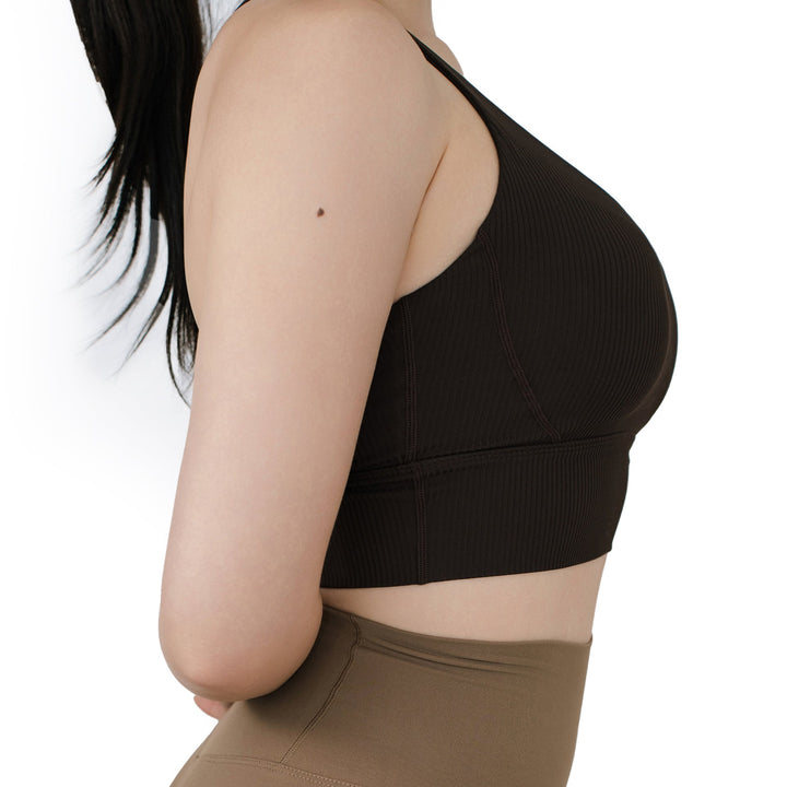 Close-up side view of the VLIZ ContourFlex Cross-Back Sports Bra in dark brown, showcasing the ribbed sculpting fabric, wide underband, and flattering seamless support.