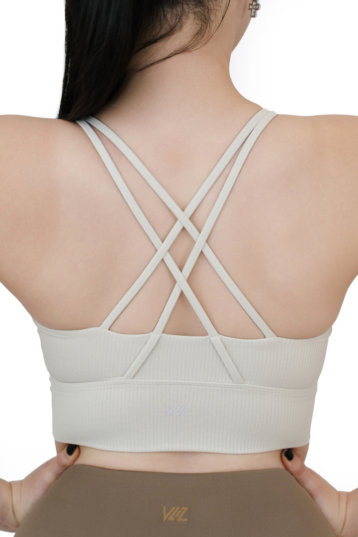 Close-up back view of the VLIZ ContourFlex Cross-Back Sports Bra in white, showcasing the double criss-cross strap design and ribbed texture.







