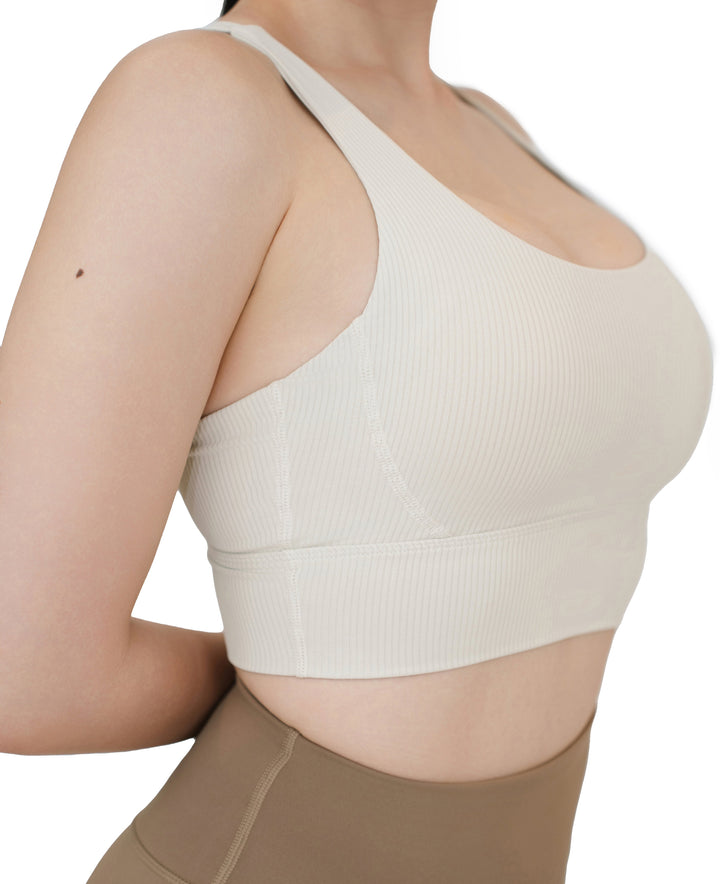 Side view of the VLIZ ContourFlex Cross-Back Sports Bra in white, highlighting the ribbed texture, contour stitching, and wide supportive underband.