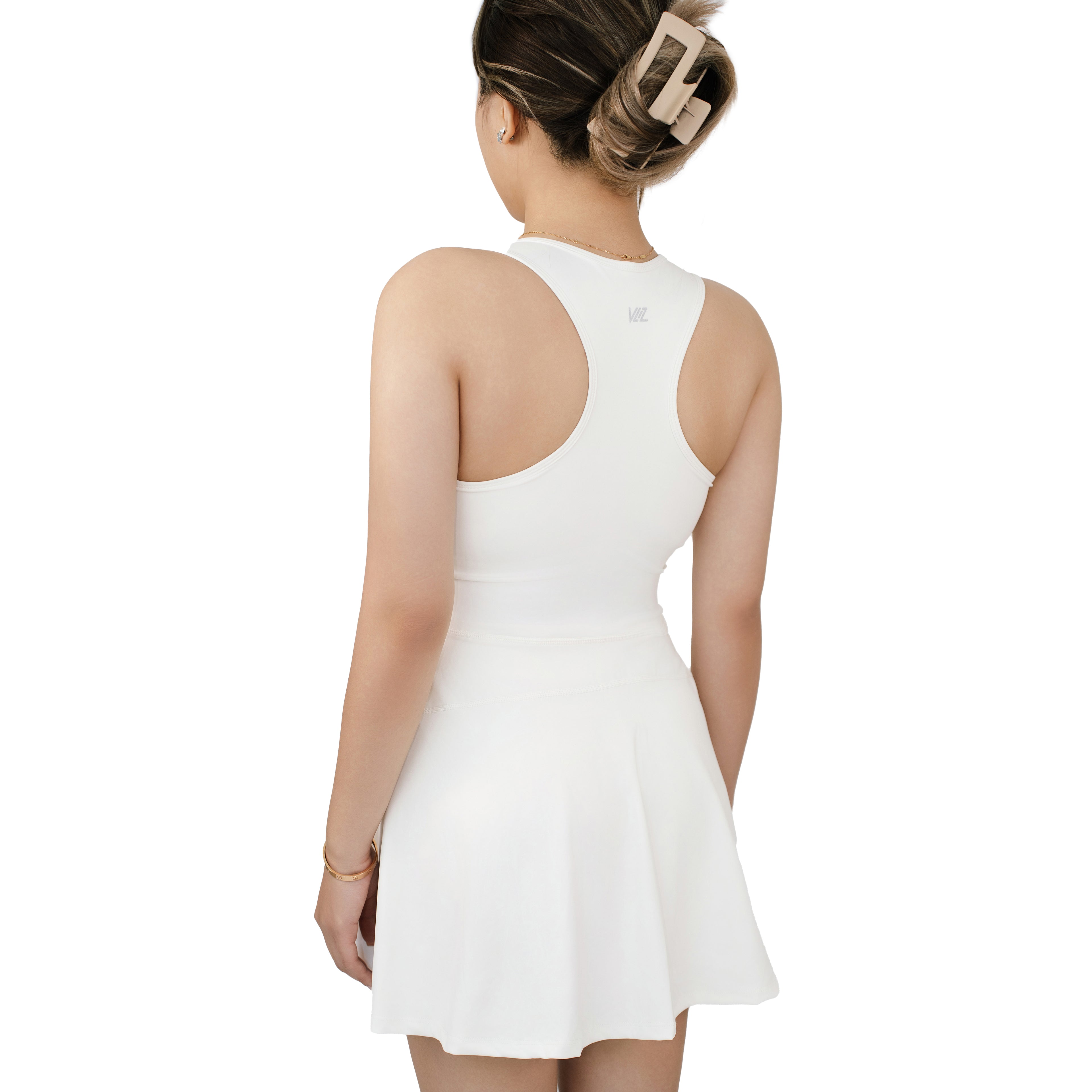Back view of model wearing the VLIZ FlowFit Tennis Dress in white, highlighting the racerback cut and flared hem.
