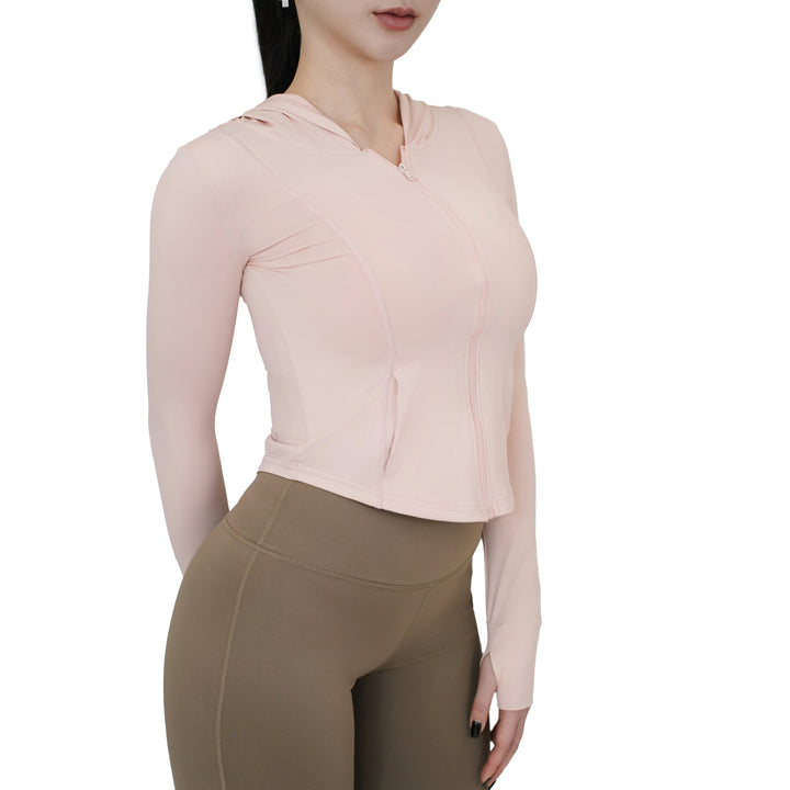 Model wearing the VLIZ Rapid UV Full Zip SlimFit Hooded Top in Peach Pink, shown from a side angle highlighting the slim-fit waistline and thumbhole sleeve detail.