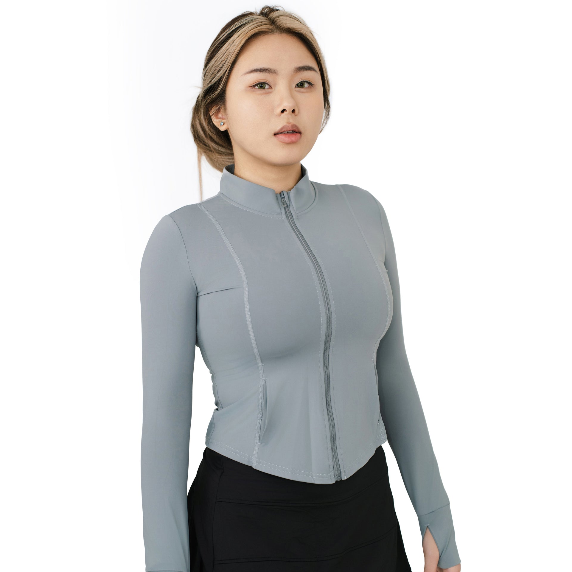 Model wearing VLIZ ash gray long sleeve full-zip top with mock neck and curved seams, facing forward at an angle with hands by her sides.