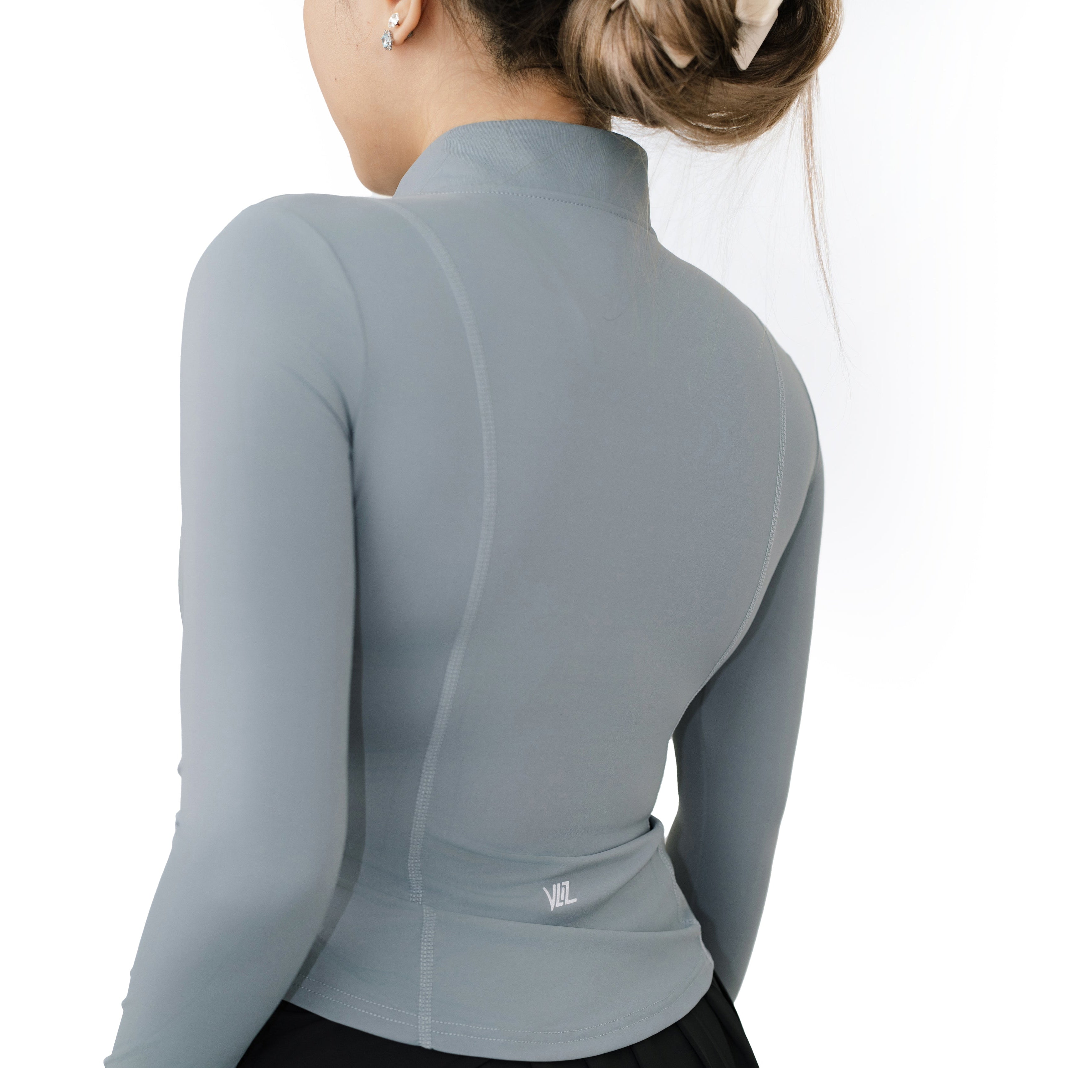 Back view of model wearing VLIZ ash gray SlimFit top, featuring contoured seams and subtle logo above the waist.