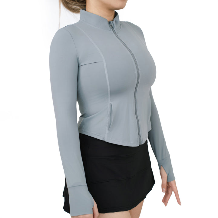 Model wearing VLIZ ash gray full-zip long sleeve top with thumbhole cuffs, shown from the side with curved seams and high collar.