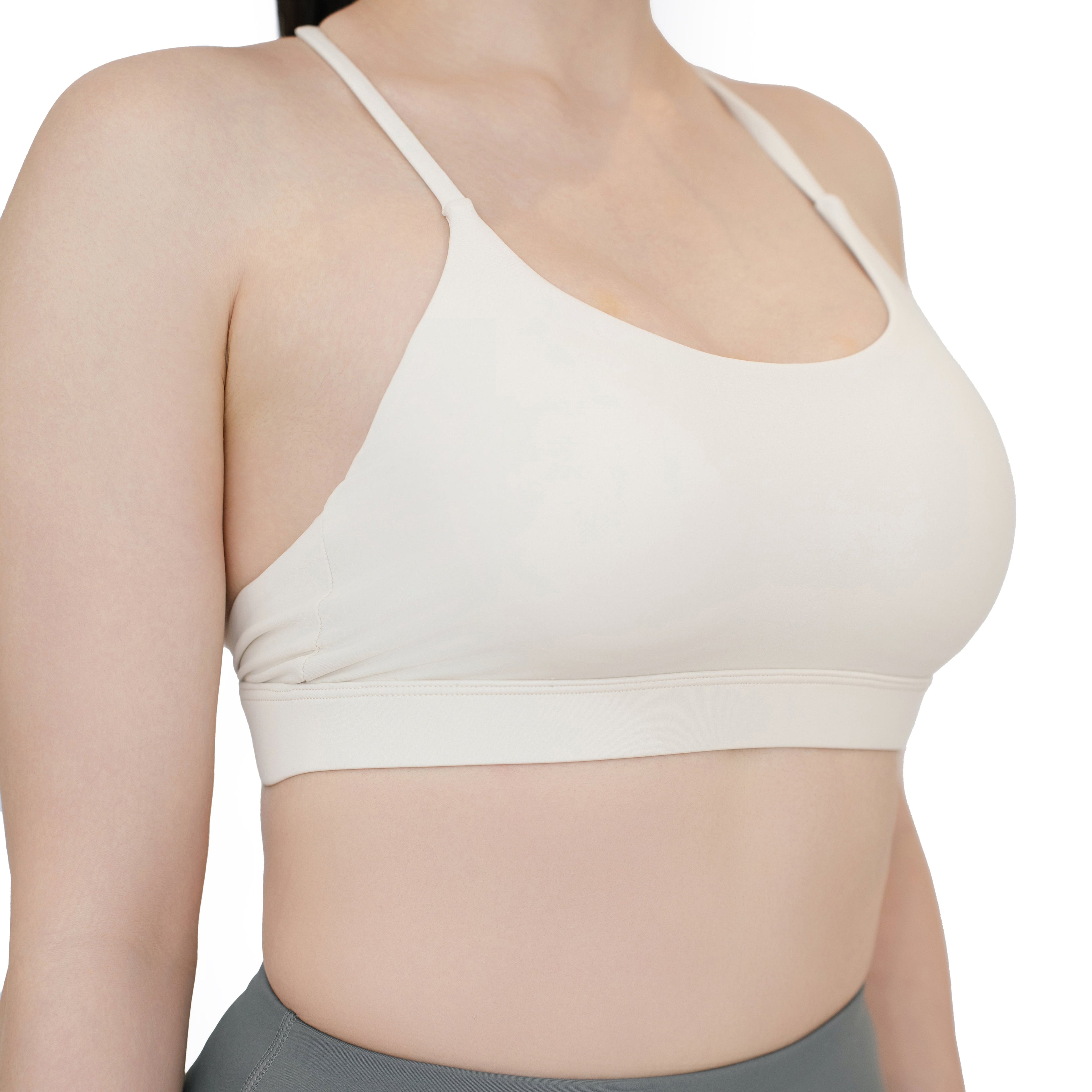 Close-up side view of the VLIZ SculptFlex Sports Bra in White, highlighting the smooth nylon fabric, curved neckline, and minimal seam detailing for a clean, supportive fit.