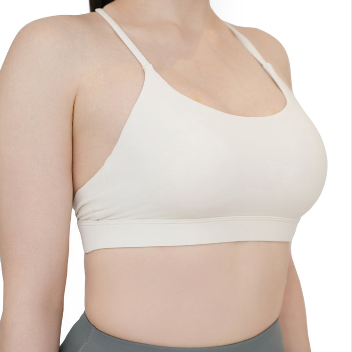 Close-up side view of the VLIZ SculptFlex Sports Bra in White, highlighting the smooth nylon fabric, curved neckline, and minimal seam detailing for a clean, supportive fit.