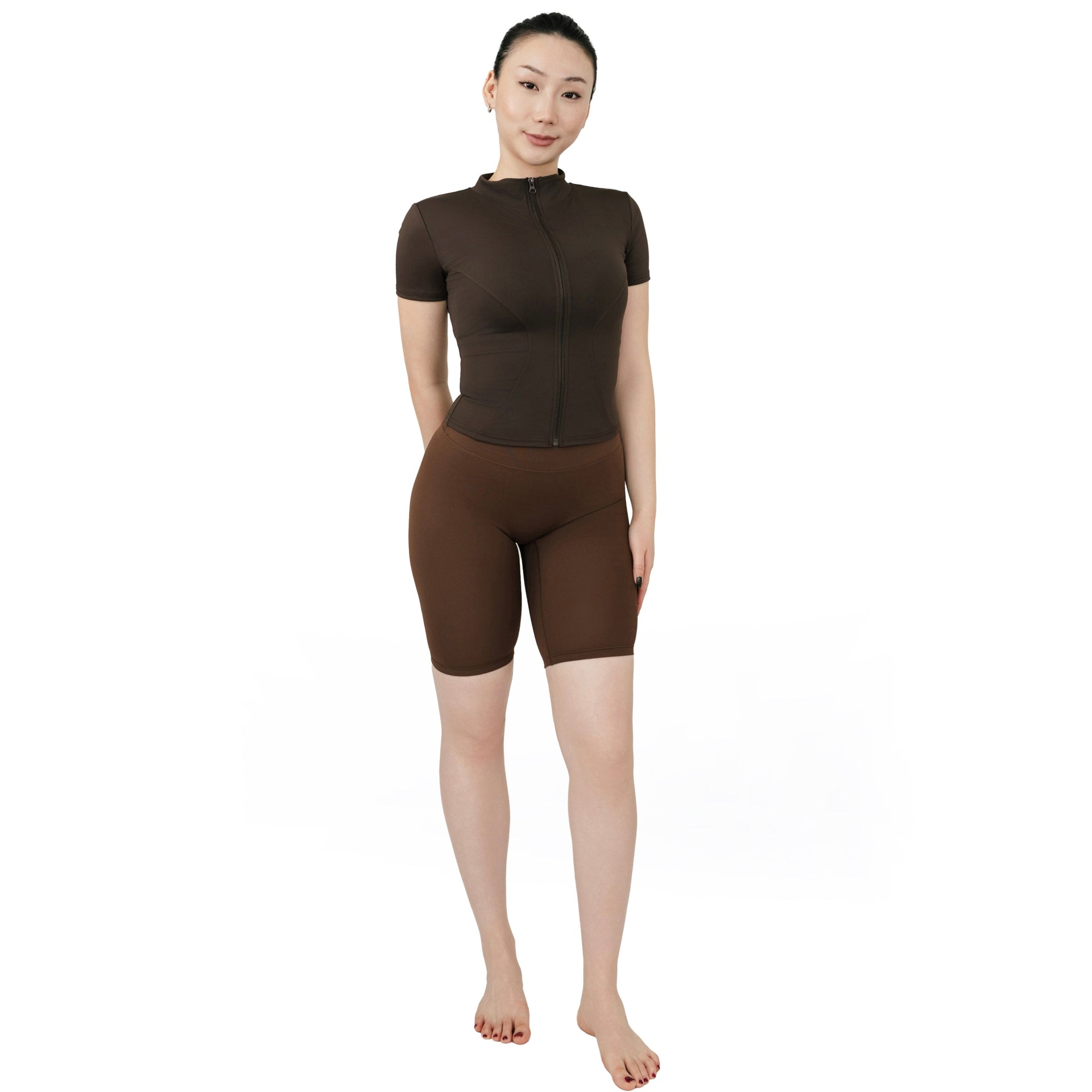 VLIZ Ultra Soft SculptFit Mid-Length Legging Shorts in chestnut brown, shown in a full front view with high waist and above-the-knee fit. Paired with a matching fitted zip-up activewear top.