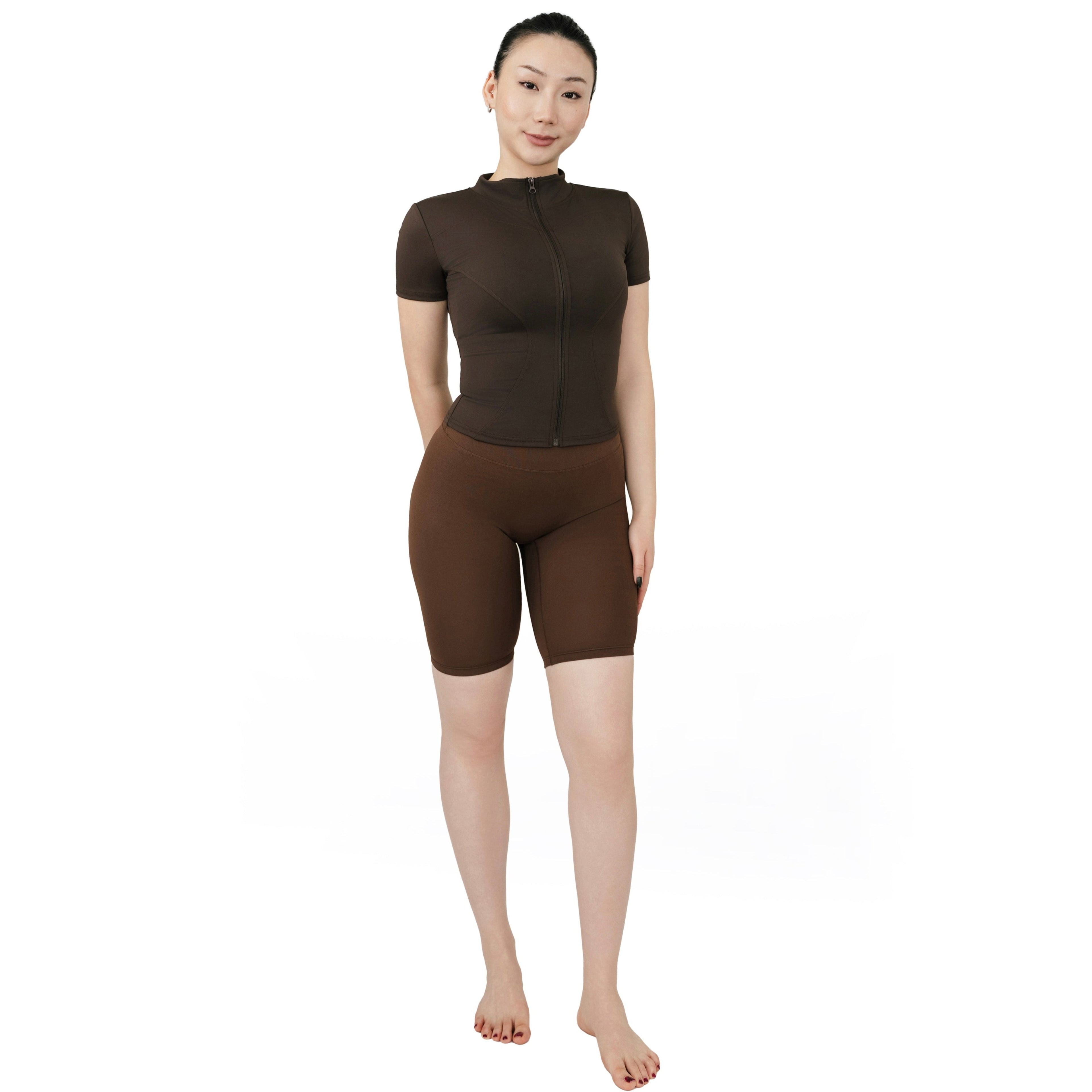 VLIZ Ultra Soft SculptFit Mid-Length Legging Shorts in chestnut brown, shown in a full front view with high waist and above-the-knee fit. Paired with a matching fitted zip-up activewear top.