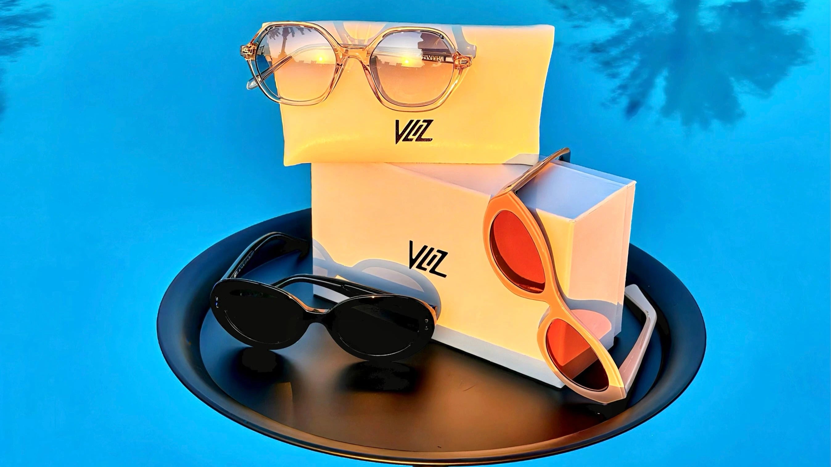 Sunglasses on a black tray with a blue background