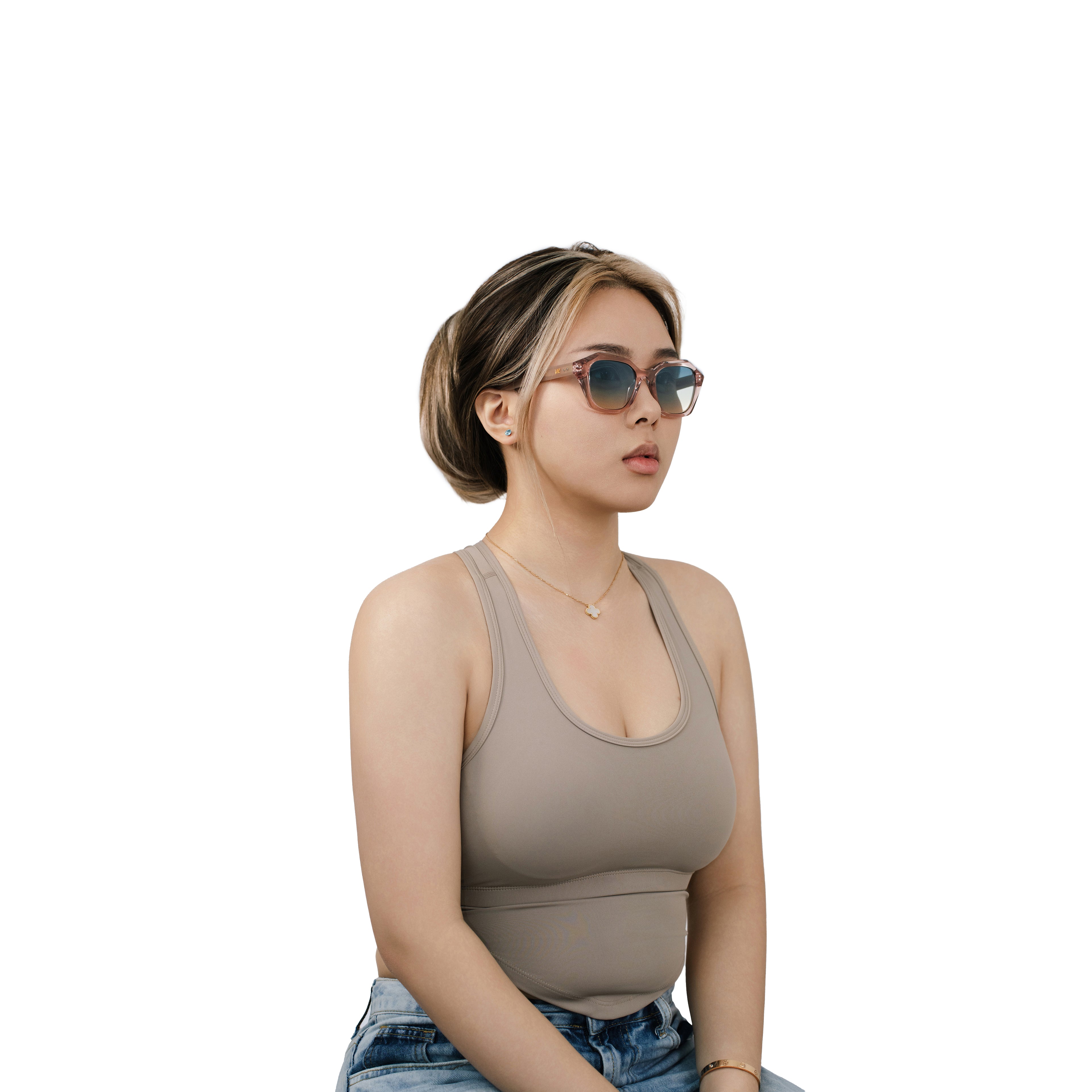 Model wearing VLIZ Altara sunglasses with a translucent pink-gradient frame and blue lenses, paired with a taupe sports tank and denim jeans, showing a soft yet modern unisex aesthetic with UV400 lens protection.
