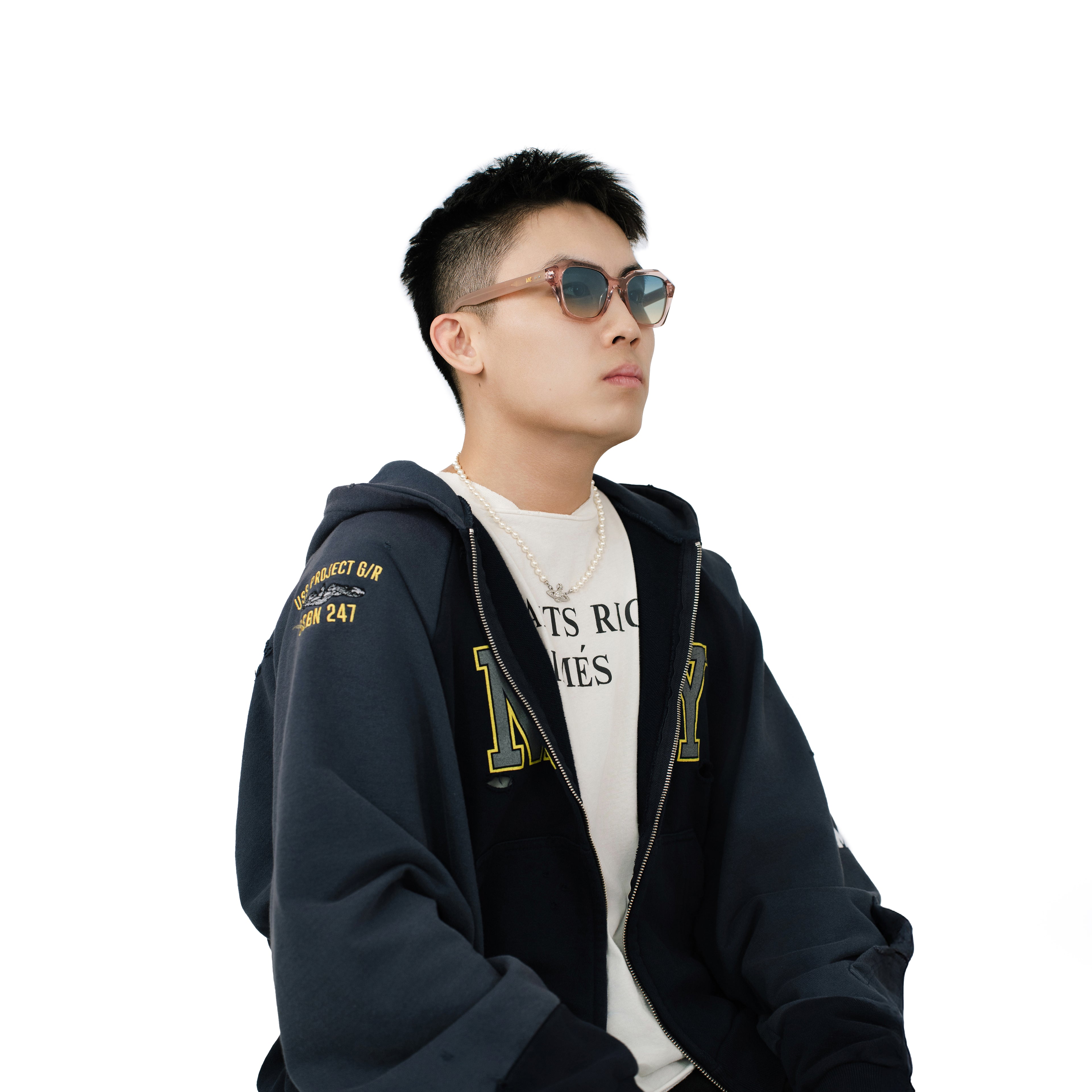 Male model wearing VLIZ Altara sunglasses with translucent pink-gradient frame and blue lenses, styled with a hoodie and graphic tee, showcasing the blend of soft-toned modern edge and unisex appeal.