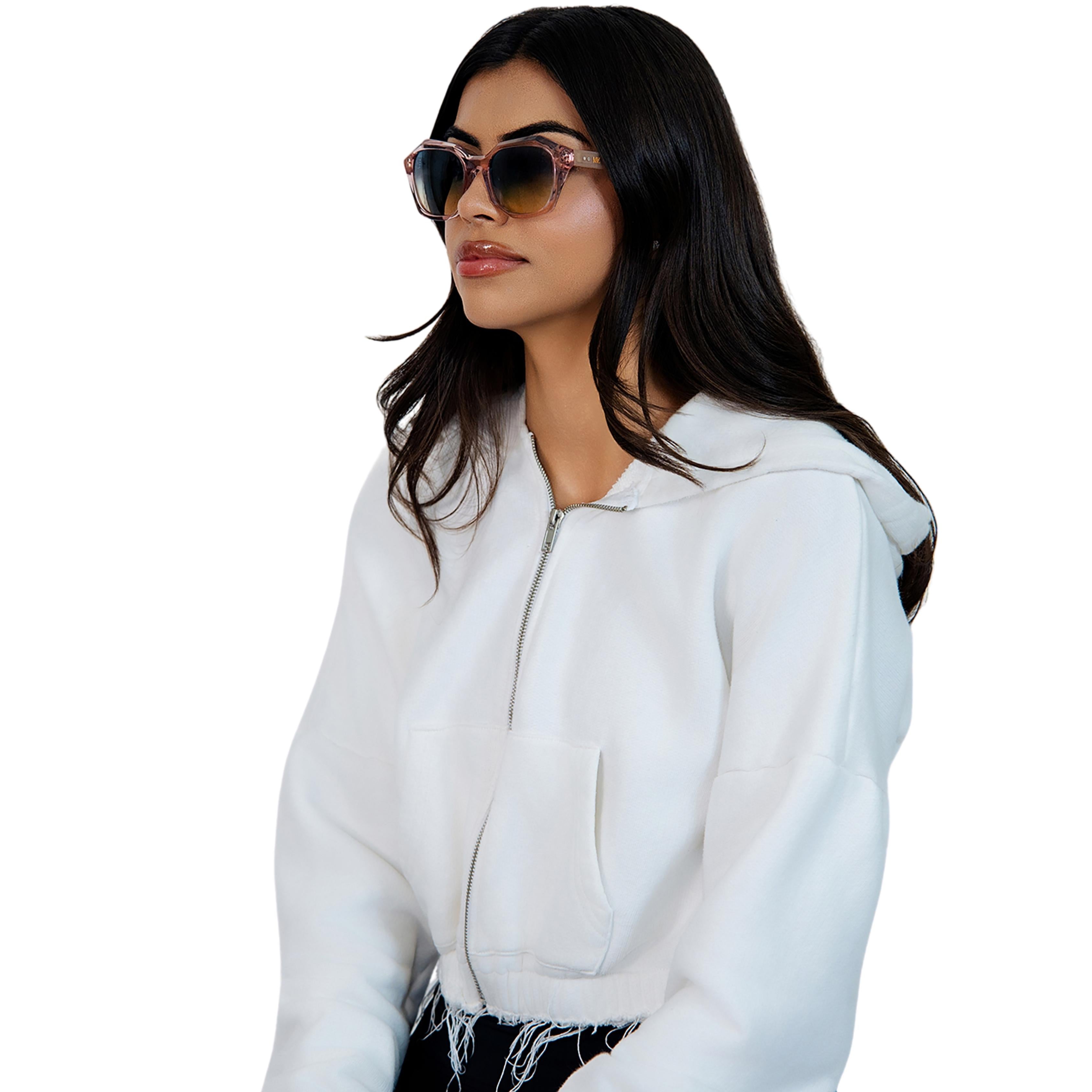 Model wearing VLIZ Altara sunglasses with a translucent pink-gradient frame and blue lenses, paired with a taupe sports tank and denim jeans, showing a soft yet modern unisex aesthetic with UV400 lens protection.