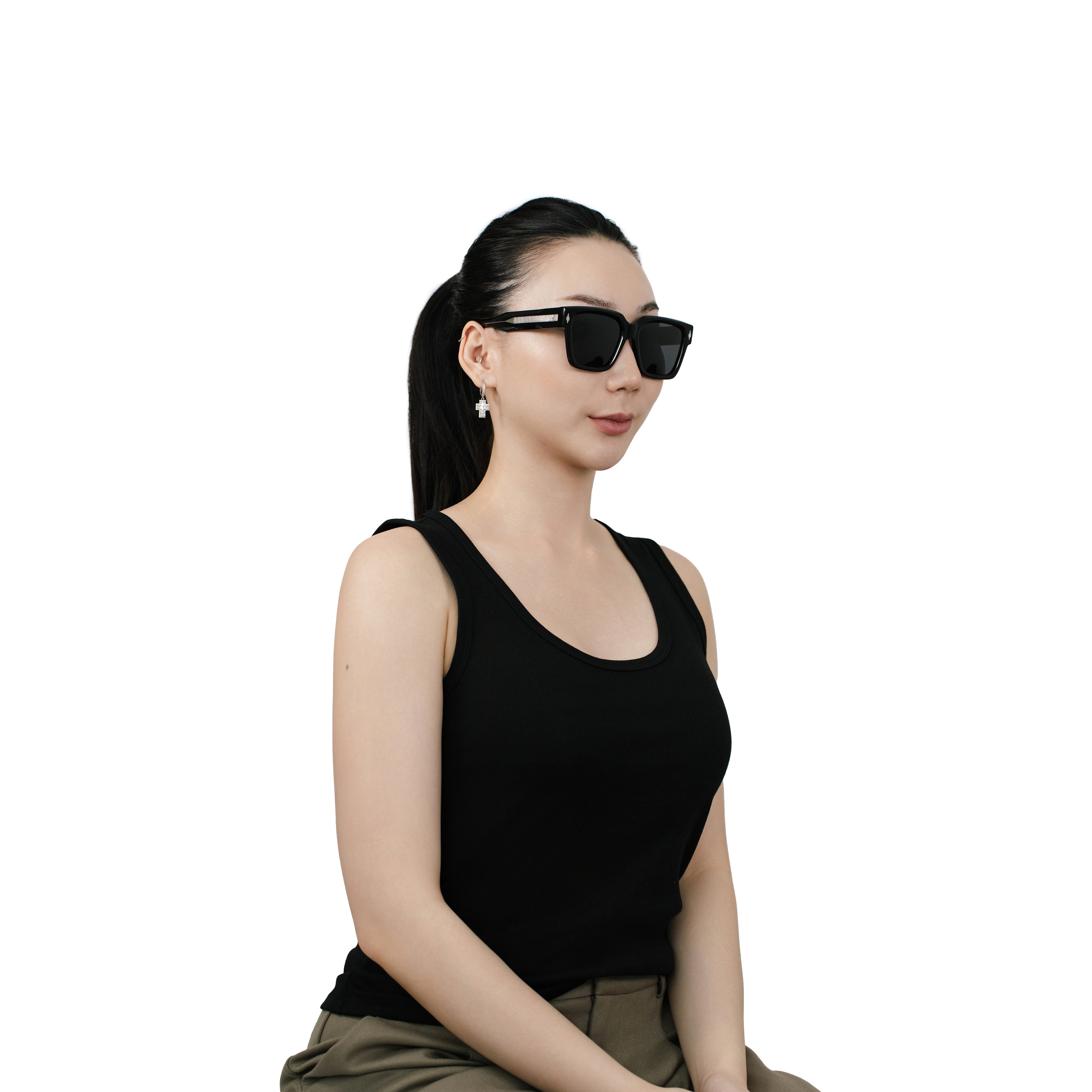 Model wearing VLIZ Gravité black square sunglasses with silver-tone temples and dark UV400 lenses, styled with a sleek ponytail and black tank top, showcasing the unisex street-luxury look.
