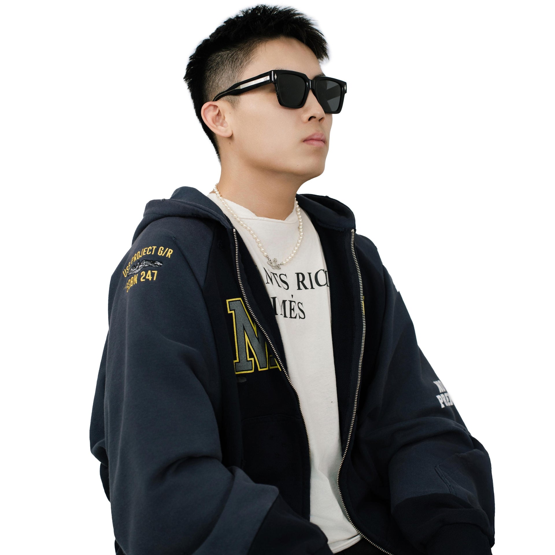Model wearing VLIZ Gravité black square sunglasses with silver-tone temples and UV400 lenses, paired with a layered hoodie and graphic tee for an effortlessly cool streetwear look.