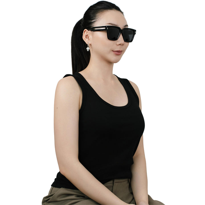 Model wearing VLIZ Gravité black square sunglasses with silver-tone temples and UV400 lenses, paired with a layered hoodie and graphic tee for an effortlessly cool streetwear look.