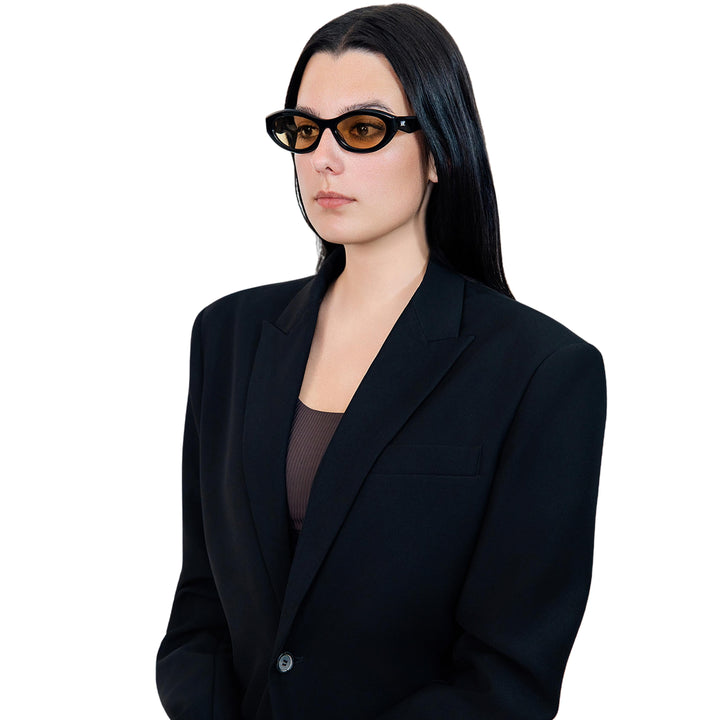 VLIZ Nolita oval sunglasses with black frame and brown lenses, featuring smooth oval design and engraved logo on temples.