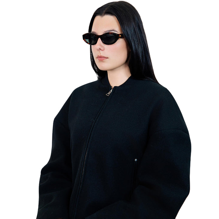 VLIZ Nolita oval sunglasses with tortoise frame and black lenses, featuring smooth oval design and engraved logo on temples.