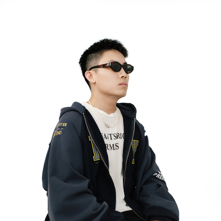VLIZ Nolita oval sunglasses with tortoise frame and black lenses, featuring smooth oval design and engraved logo on temples.