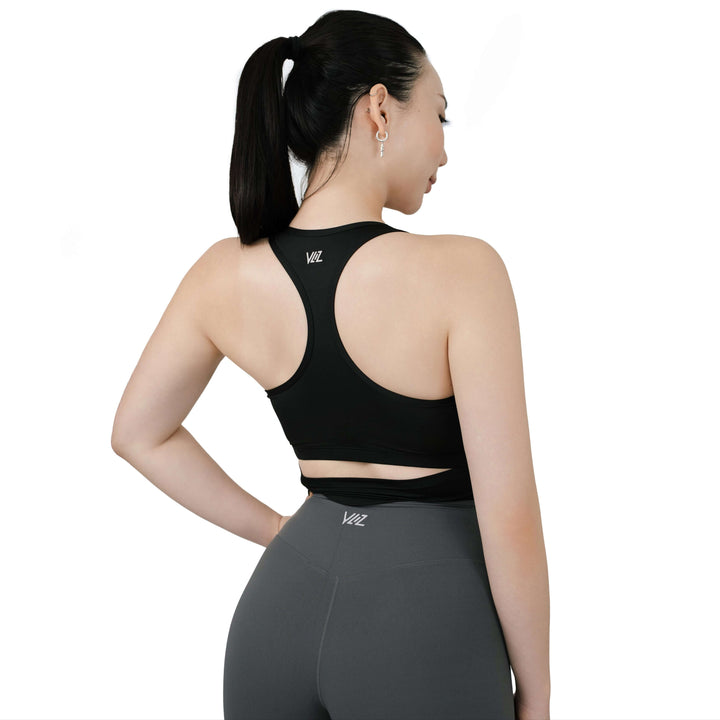Centered back view of VLIZ SculptFit Racerback Sports Bra in black, highlighting the racerback cut, upper-back logo, and curved underband cutout.

