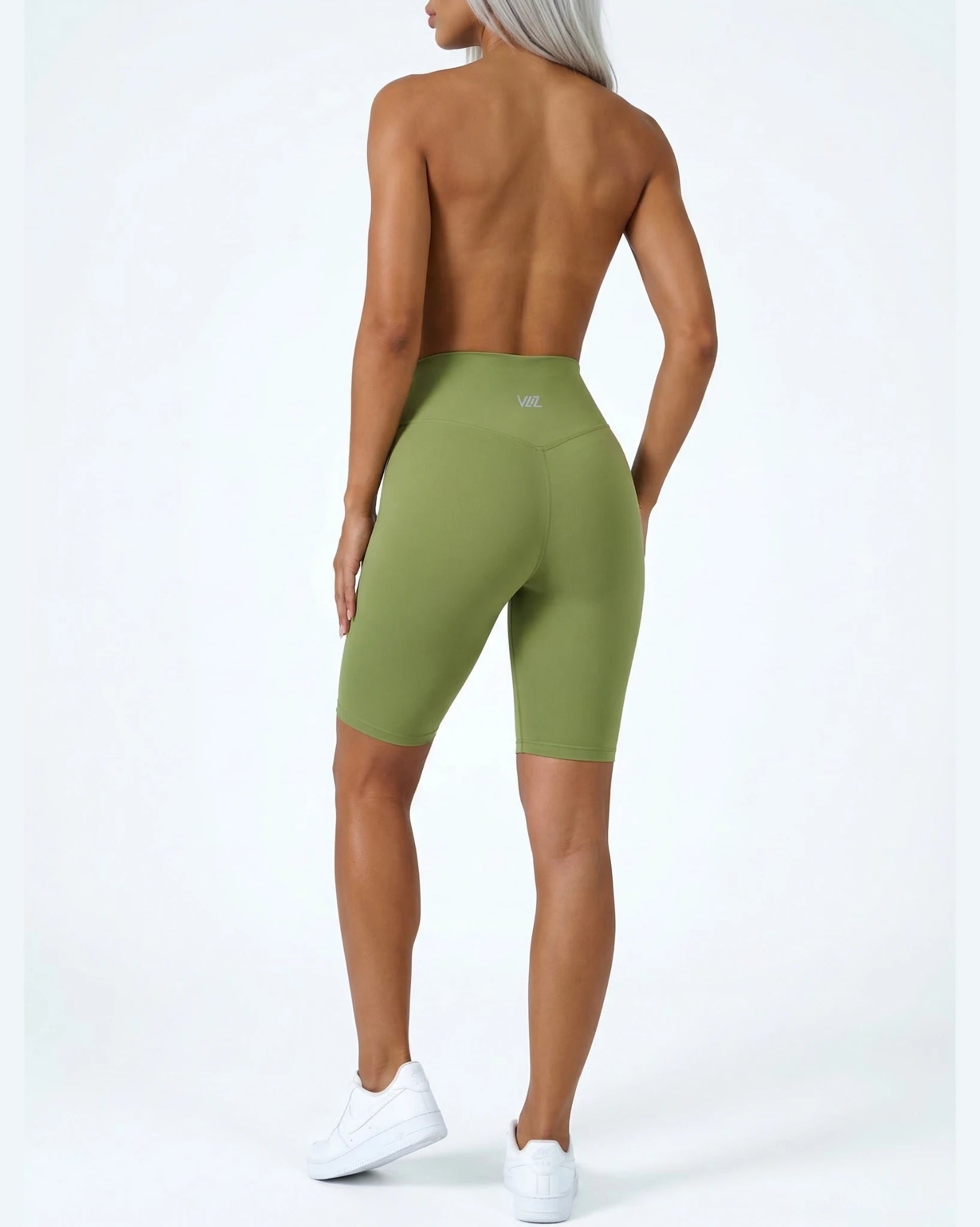 Person wearing green athletic shorts on a white background