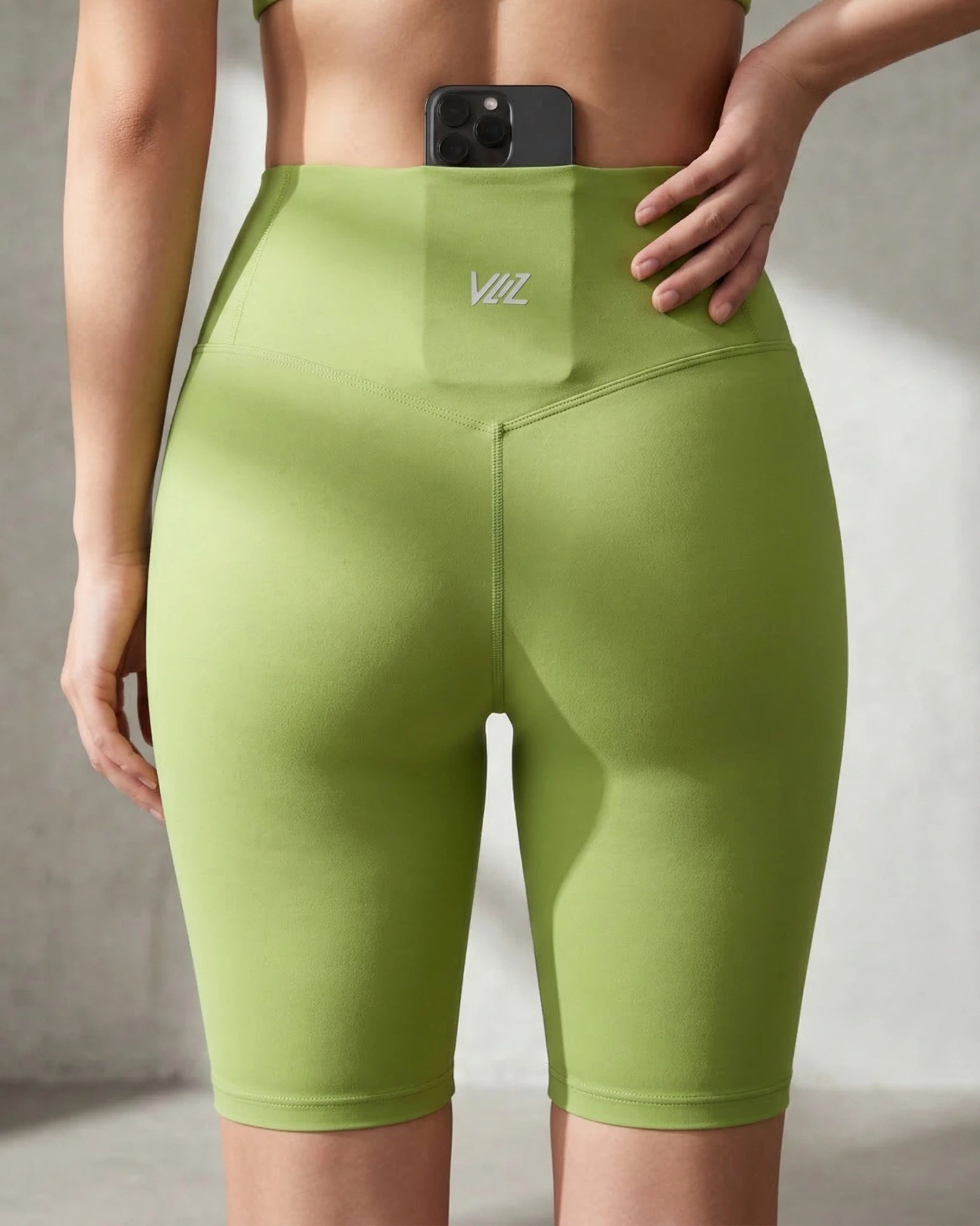 Green athletic shorts with a brand logo on a neutral background