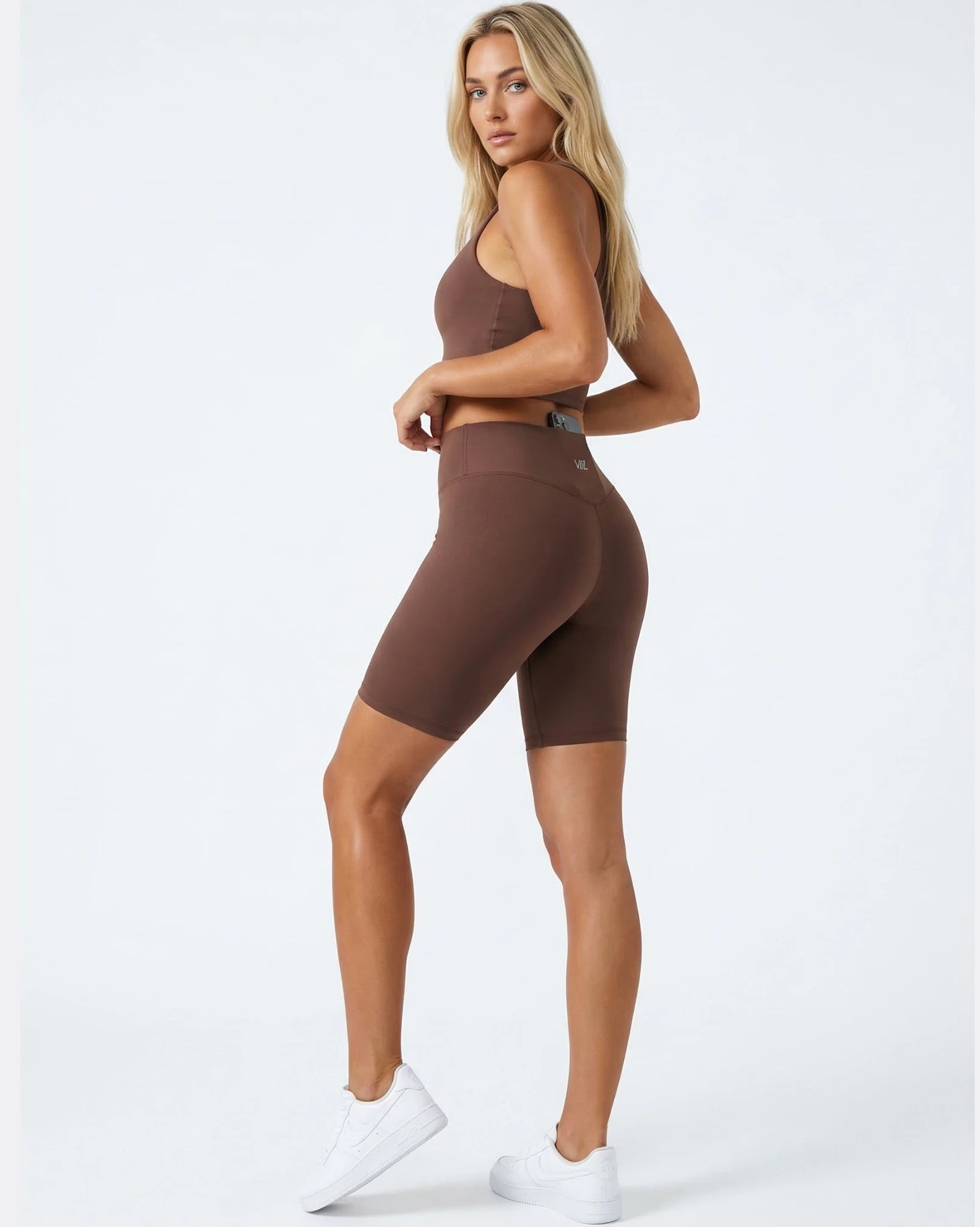 Woman wearing a brown athletic outfit on a white background