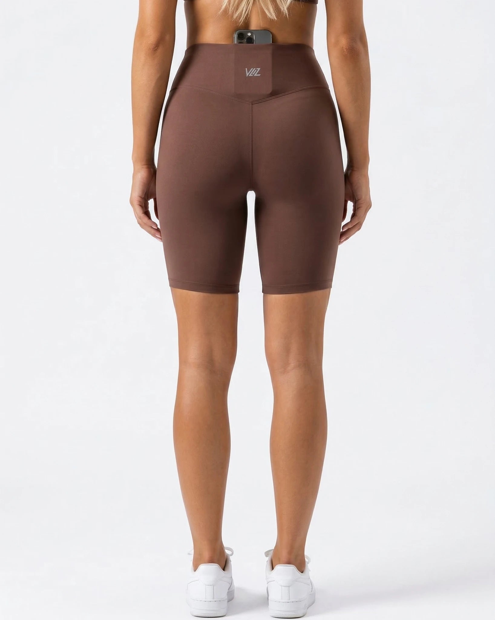 Brown high-waisted leggings worn by a person on a white background