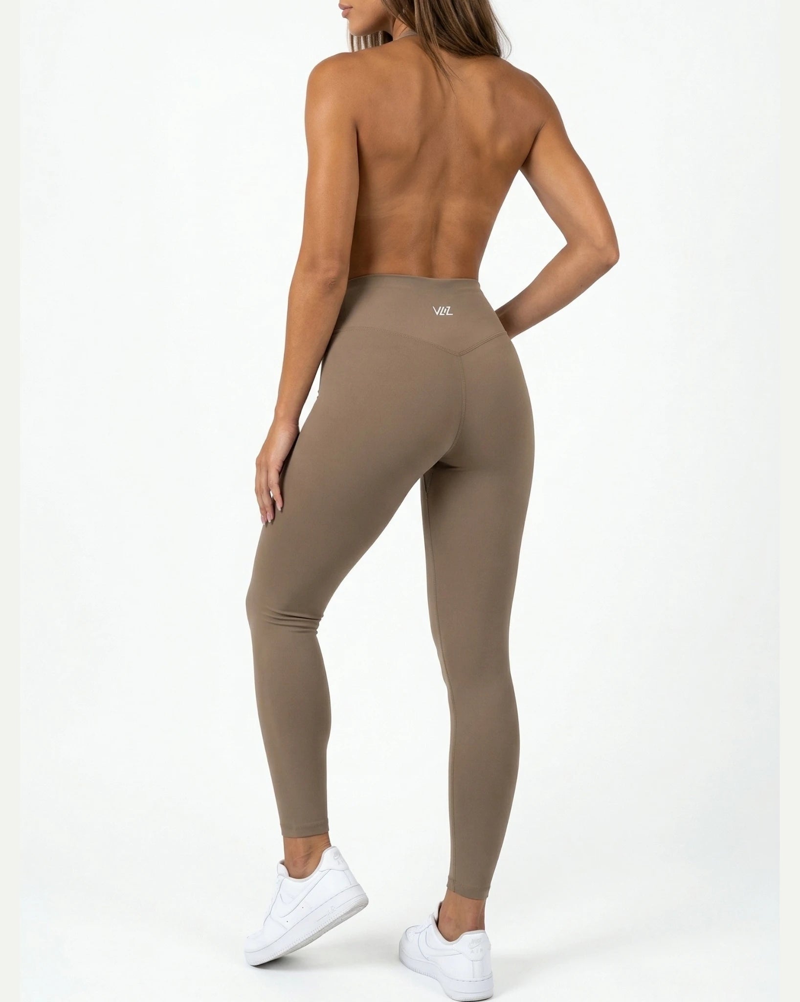 Person wearing brown leggings on a white background