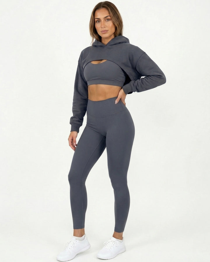 Woman wearing a gray hoodie and leggings set on a white background