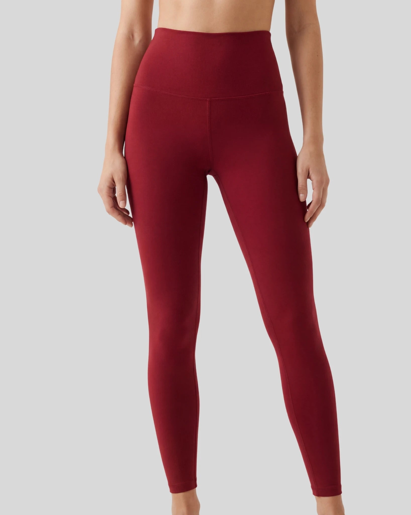 Maroon leggings worn by a person on a light gray background