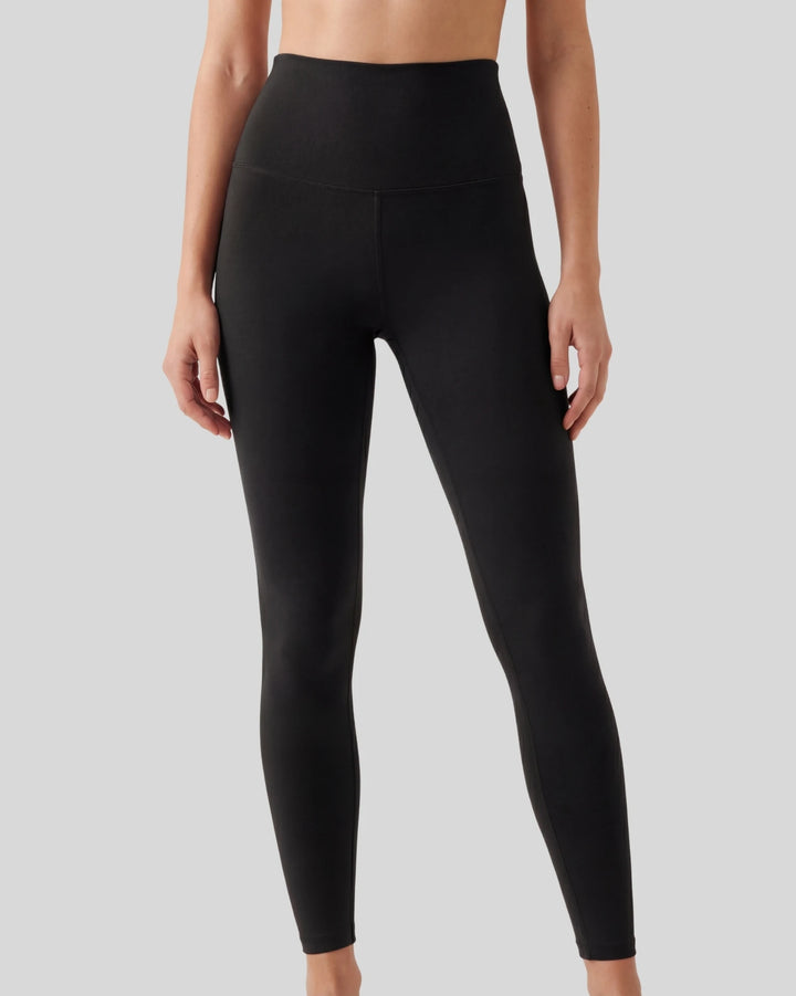 Black leggings worn by a person on a gray background