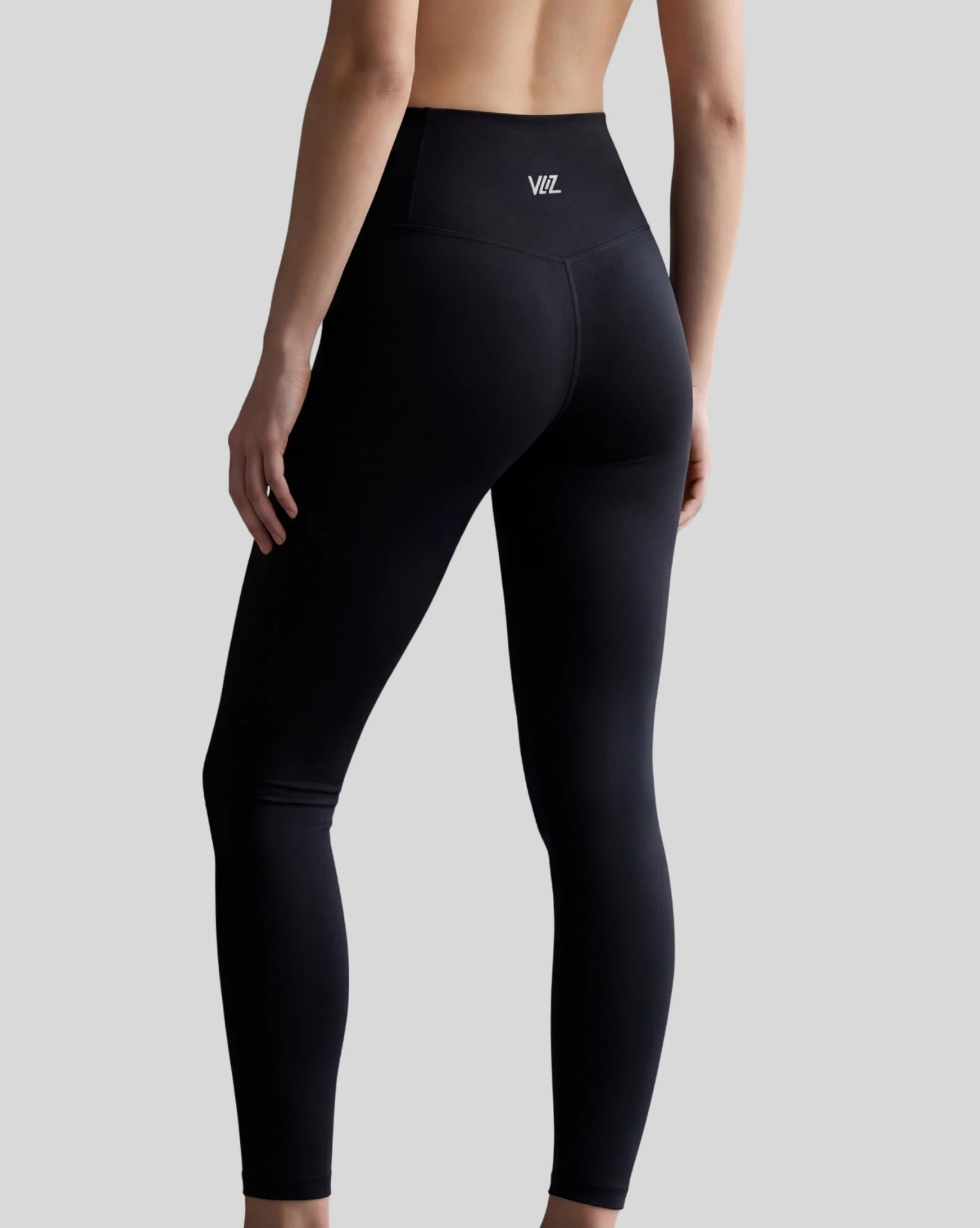 Black leggings with a brand logo on a gray background