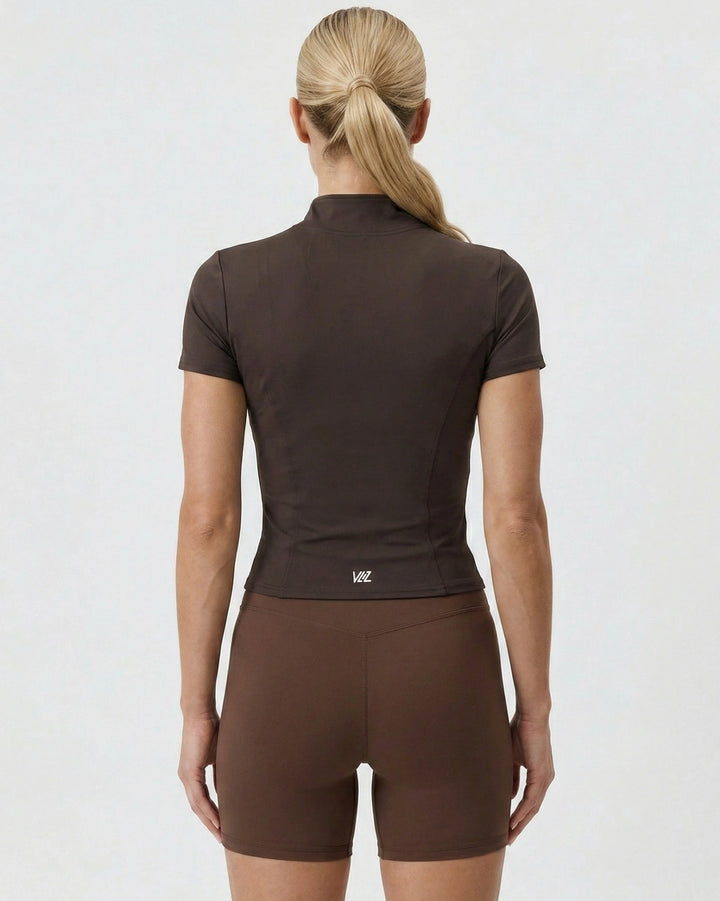 Woman wearing a brown athletic outfit on a white background