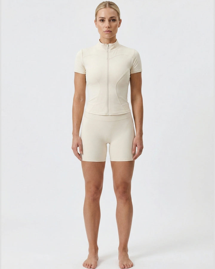 Person wearing a beige bodysuit on a white background