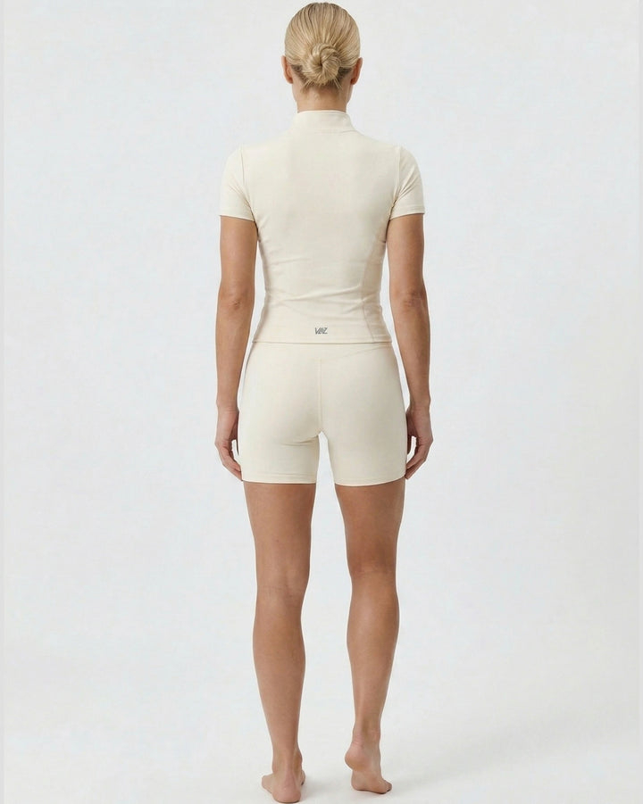 Person wearing a beige bodysuit on a white background