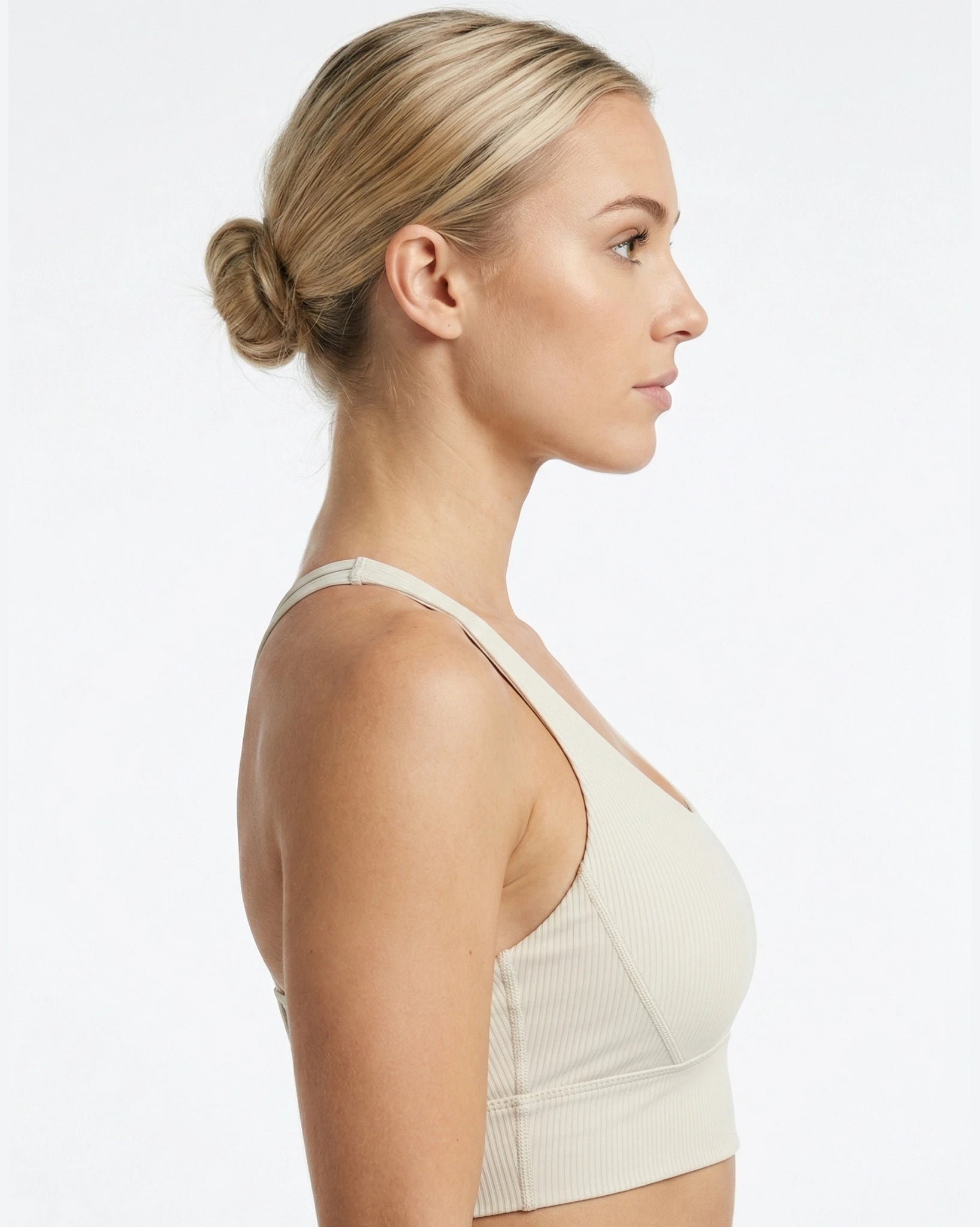 Woman wearing a beige sports bra on a white background