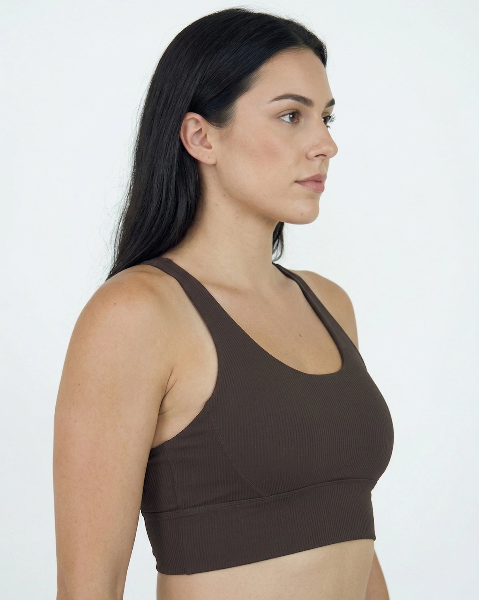 Woman wearing a brown sports bra against a white background
