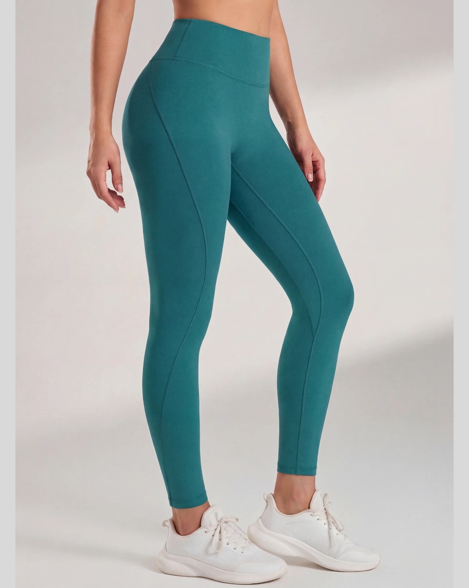 Teal leggings worn by a person on a plain background